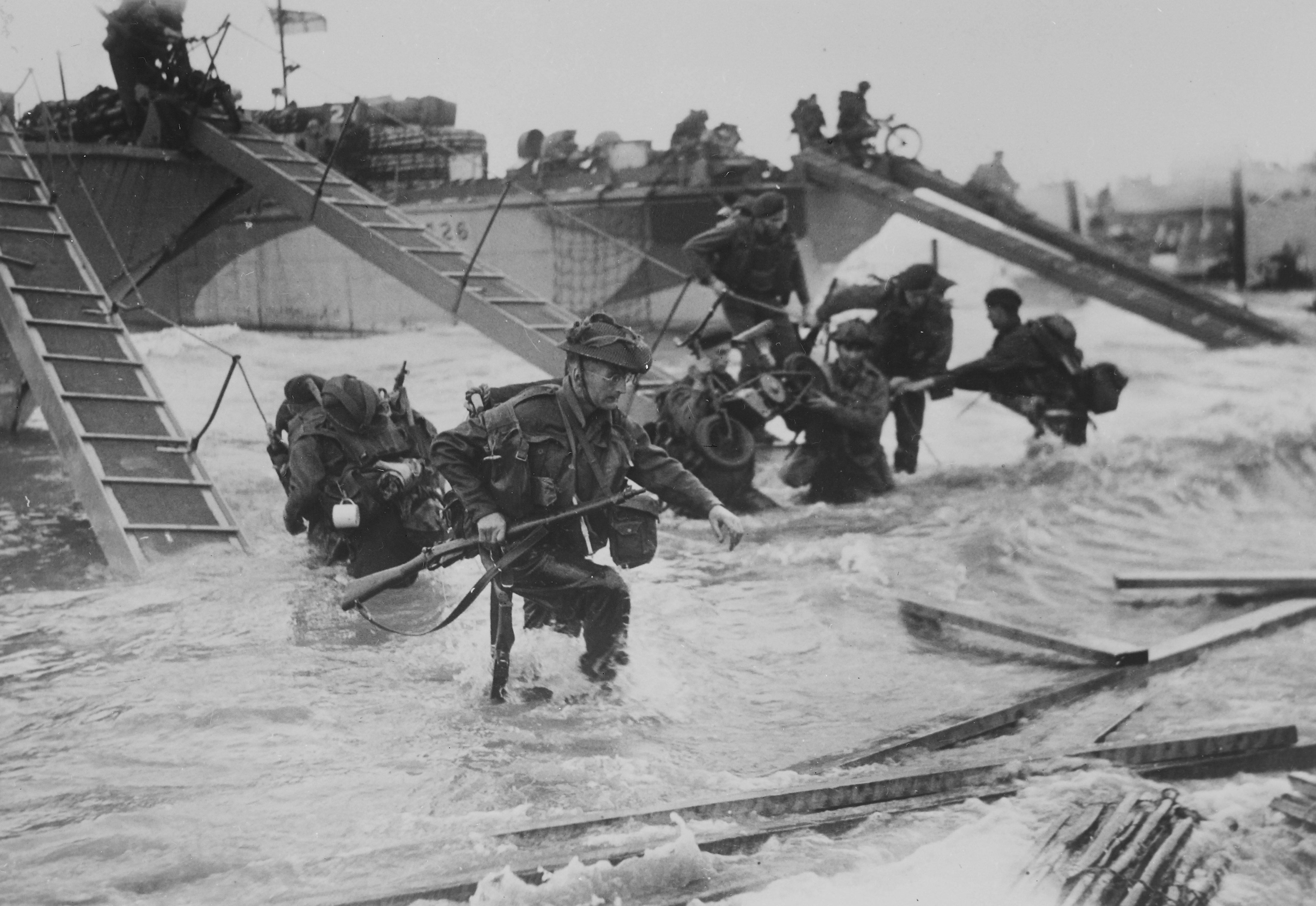 Black and White image showing Soldiers leaving their boats to fight on D-Day