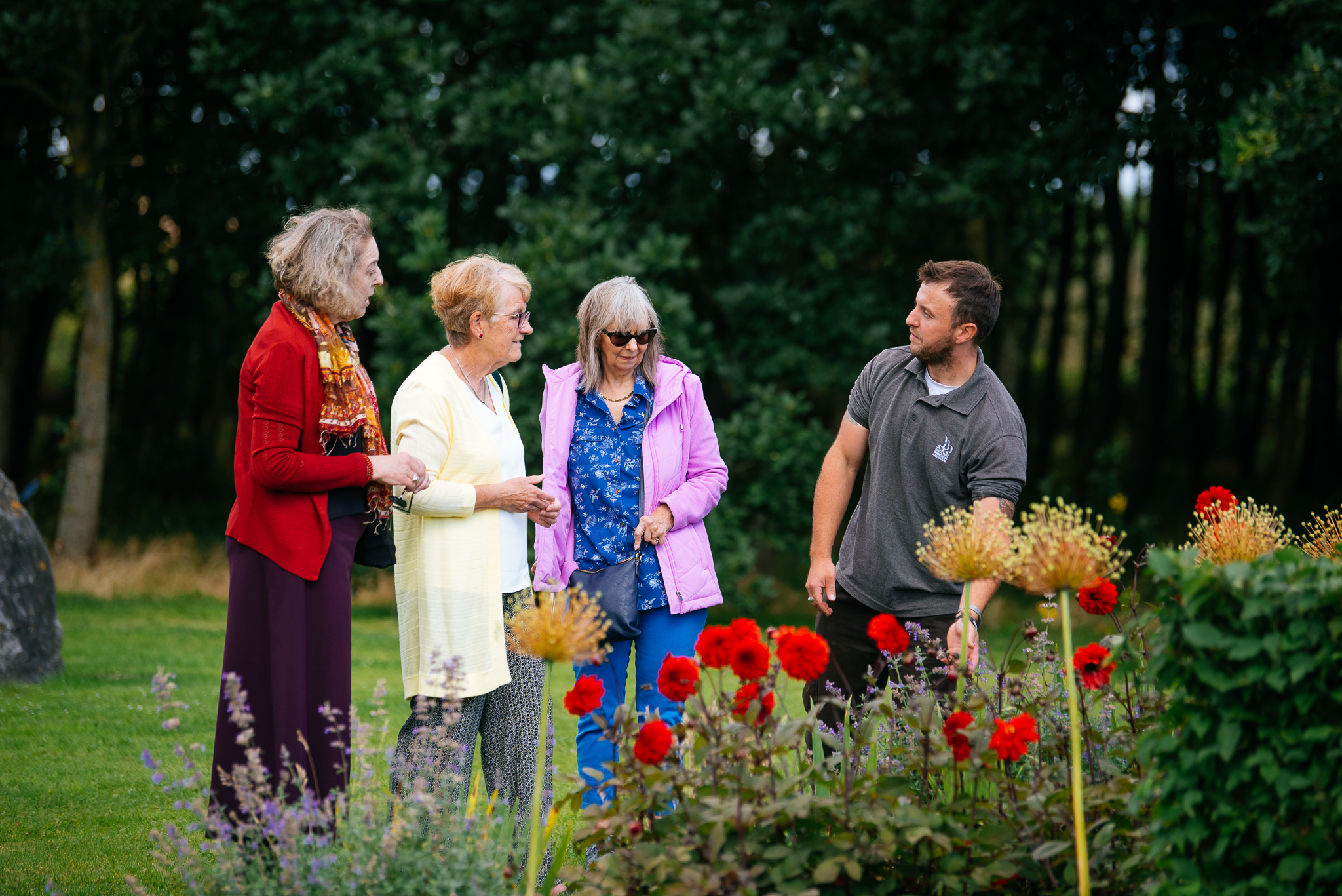 A group of three people talking to a gardener